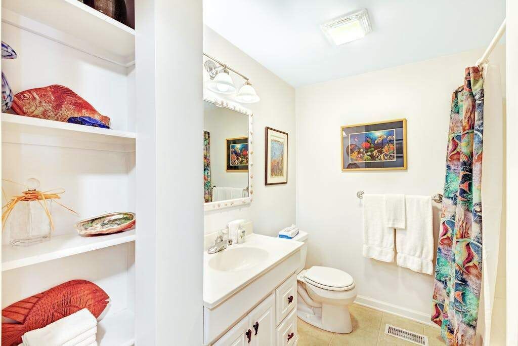 Une salle de bain équipée d’un lavabo, de toilettes et d’un rideau de douche.