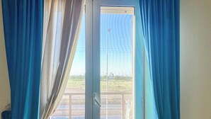 Una habitación con puerta corrediza de vidrio que da a un espacio exterior.