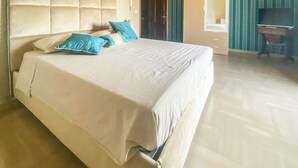 Habitación de hotel con una cama grande, un escritorio de madera y un espejo.