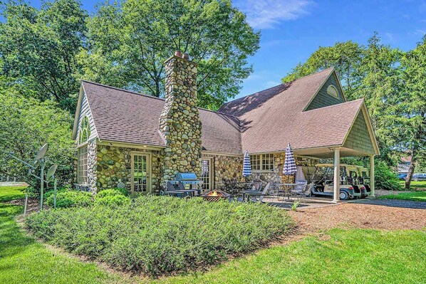 A stone building with a covered patio, satellite dishes, and a golf cart.