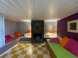 A cozy living room with a checkered floor, a fireplace, and two sofas with colorful cushions. - Villa-Agave, by the sea in Porto-Rafti outside ATH (Porto Rafti)