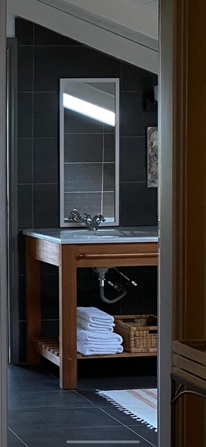 A bathroom with a wooden vanity, a large mirror, and a tiled floor. - Villa-Agave, by the sea in Porto-Rafti outside ATH (Porto Rafti)
