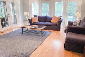 A living room with a dark-colored sofa, a glass coffee table, and two lamps on side tables. - Well-kept home with private outdoor pool, free WiFi, and pool table (Sawyer)