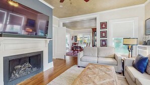 Una sala de estar con chimenea, sofá, mesa de centro y televisor.