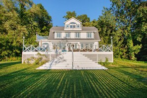 A two-story house with a front porch, a covered deck, and a well-maintained lawn. - Exclusive beach access, serene views, and family-friendly amenities (Coloma)