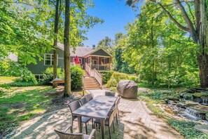 A house with a porch, a staircase leading to the entrance, and a garden with a patio table and chairs. - Dog-friendly home with woodland surroundings- next to Clearbrook Golf Course (Saugatuck)