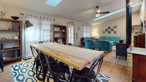 Ein Wohnzimmer mit einem Holztisch, Stühlen, einem Sofa und einem Deckenventilator.
