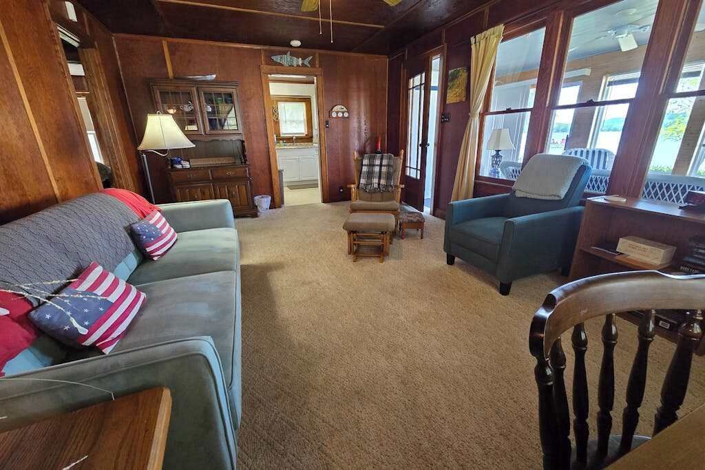 A cozy living room with a sofa, armchairs, and a wooden floor.