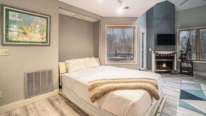 Une chambre à coucher avec un lit, une cheminée, un téléviseur et une carte accrochée au mur.