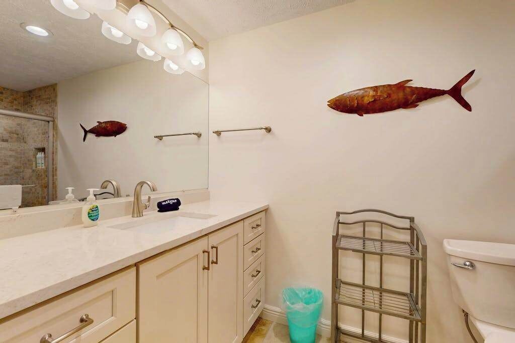 A bathroom with a sink, mirror, towel rack, and toilet.