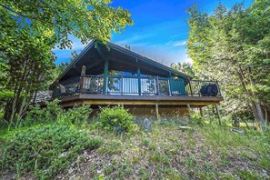 Eine Hütte mit Balkon, umgeben von Bäumen.