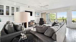 Un salon moderne avec une cheminée, un canapé, une table basse et un ventilateur de plafond.