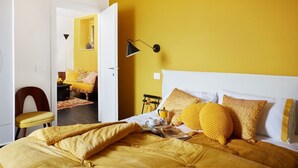 A room with a bed, a chair, a lamp, and a doorway leading to another room. - La Camerata - One Bedroom Villa, Sleeps 2 (Spello)