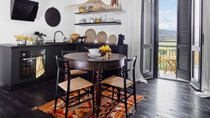 A modern kitchen with a dining table, chairs, and a view of the outdoors. - La Camerata - One Bedroom Villa, Sleeps 2 (Spello)