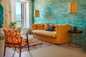Una habitación con un sofá, una silla, una mesa y una lámpara colgante.