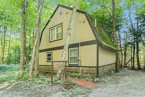 A cabin with a pitched roof, a front window, and a sign indicating it is the Hidden River Cabin.