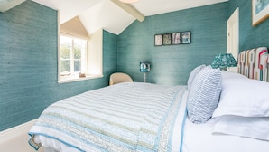 A bedroom with a large bed, a window, and a ceiling with exposed beams. - Heatherstone House - Six Bedroom Villa, Sleeps 10 (Broughton)