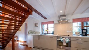 Una cucina moderna con una scala in legno, elettrodomestici in acciaio inossidabile e una finestra con vista.