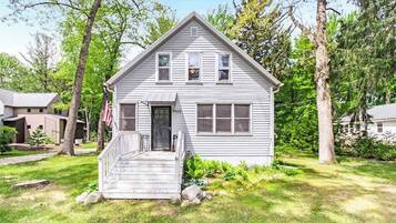 A single-story house with a front porch, a garage, and a small front yard.