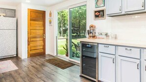 A kitchen with wooden flooring, a built-in oven, and light blue cabinets.