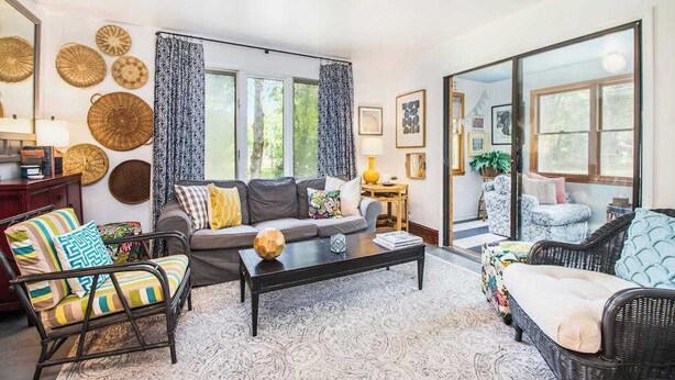 A living room with a sofa, armchairs, a coffee table, and a large window.