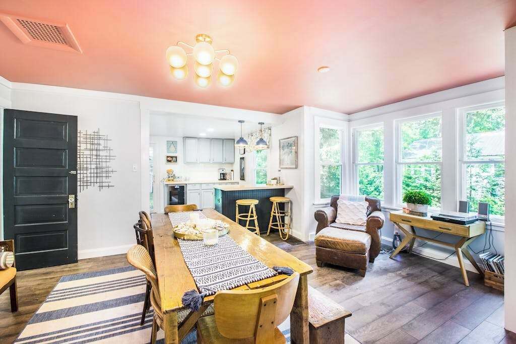 Un salon spacieux avec une table à manger en bois, un canapé et un bureau équipé d’un ordinateur.
