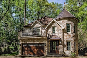 A stone house with a turret, a garage, and a balcony. - Classic home w/ private hot tub, sauna, & outdoor fireplace - 350 feet to beach (New Buffalo)