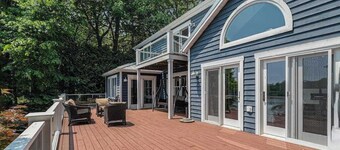 Serene lakefront retreat with an expansive deck, dock access, game room, & AC