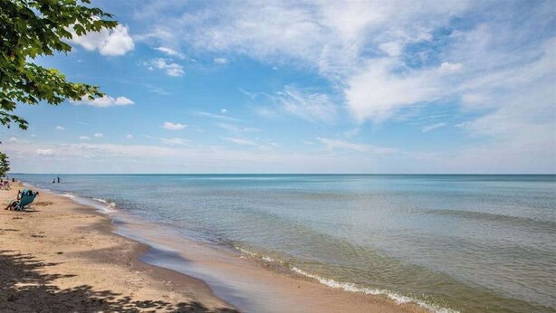 Una spiaggia con acque cristalline, una riva sabbiosa e alcune persone.