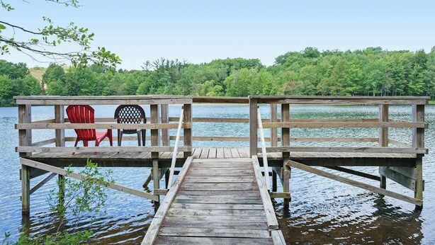 Puinen laituri, joka ulottuu järvelle, ja josta avautuu näkymä metsäiselle alueelle.