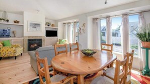 Un comedor con una mesa redonda de madera, sillas y una chimenea.