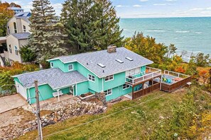 A turquoise house with a large deck and a view of the ocean. - Lake Michigan Retreat w/ stunning views, hot tub, & large patio! (Michiana)