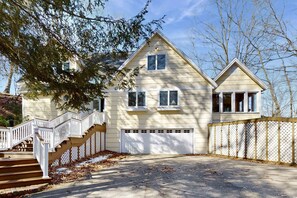 A two-story house with a front porch, a garage, and a fenced yard.