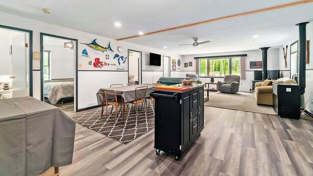 A spacious living area with a dining table, a sofa, and a TV. - Cardinal Cabin | House in Honor (Honor)