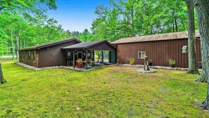 A rustic cabin with a covered porch, a small deck, and a well-maintained lawn. - Cardinal Cabin | House in Honor (Honor)