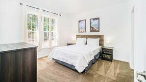 A bedroom with a bed, bedside tables, a nightstand, a dresser, and two framed pictures on the wall. - Secluded & contemporary cottage with a washer/dryer, central AC, & firepit (Honor)