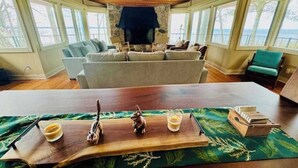 Una sala de estar acogedora con chimenea, una mesa de centro de madera y vistas al exterior.