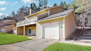A two-story residential building with a garage, a covered porch, and a small front yard. - Spacious 3-level retreat w/ fireplace, wet bar, deck, tennis, skiing & golf near (Harbor Springs)