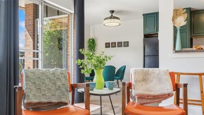 A modern kitchen with teal cabinets, a black refrigerator, and a hanging plant. - The Aviary Near CSU | Pool, Sauna, and Gym (Fort Collins)