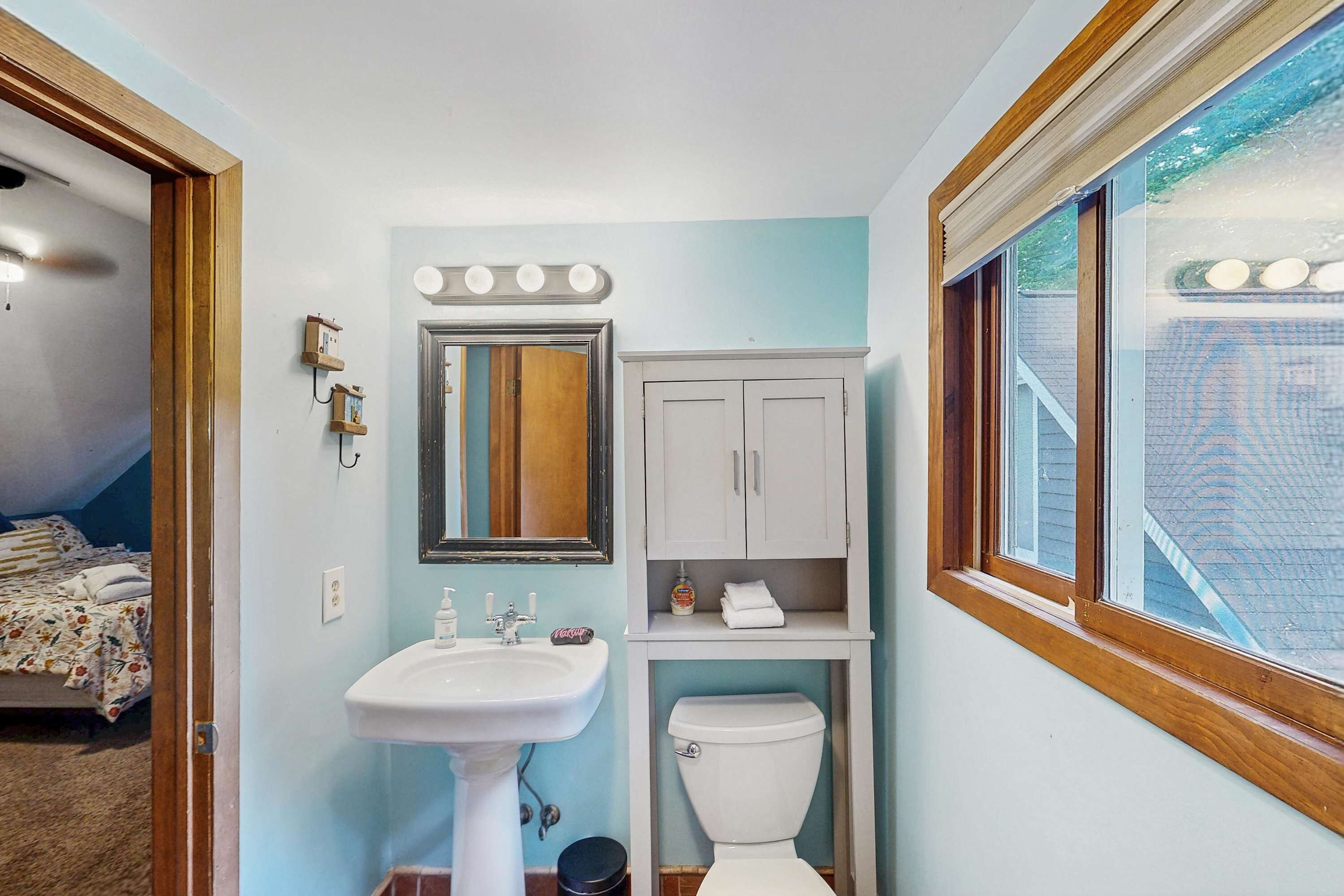 Une salle de bain équipée d’un lavabo, d’un miroir, d’un meuble-lavabo et de toilettes.