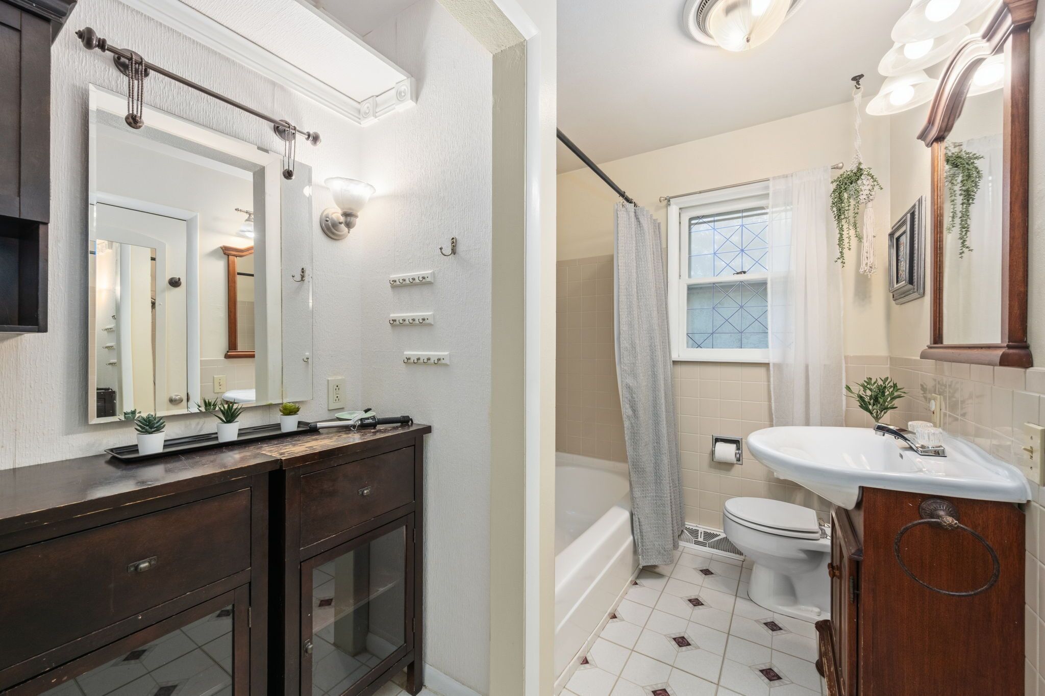 A bathroom with a bathtub, toilet, and vanity with a mirror.
