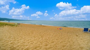 Una spiaggia sabbiosa con un cielo azzurro limpido e un mare calmo.