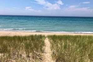 Ein Strand mit einem sandigen Pfad, der zum Meer führt.