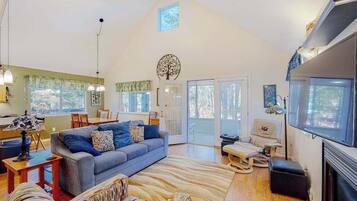 A spacious living area with a sofa, a dining table, and a fireplace.