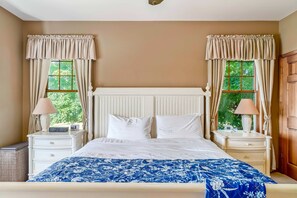 A bedroom with a bed, two bedside tables, a nightstand, a lamp, and curtains. - Gorgeous, dog-friendly home near the lake with fireplace, grill & washer/dryer (Arcadia)