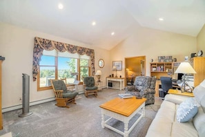 A living room with a fireplace, a bookshelf, and a window with curtains. - Gorgeous, dog-friendly home near the lake with fireplace, grill & washer/dryer (Arcadia)