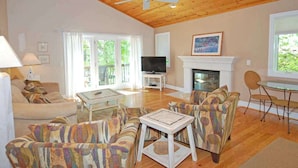 A living room with a fireplace, television, and seating area. - Spacious lake access home with a washer/dryer, central AC, nearby tennis (Glen Arbor)