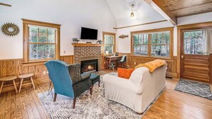 A cozy living room with a fireplace, wooden floors, and large windows. - Secluded home w/ private grill, gas fireplace, full kitchen, and free WiFi (Arcadia)