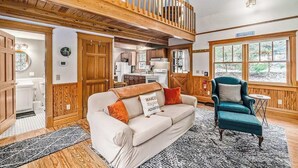 A spacious living area with a high ceiling, wooden beams, a sofa, a chair, and a view of the outdoors. - Secluded home w/ private grill, gas fireplace, full kitchen, and free WiFi (Arcadia)