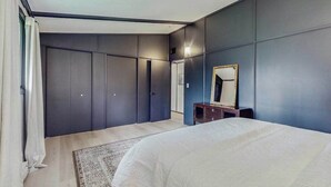 Une chambre à coucher avec un lit, une armoire, un miroir et un tapis.